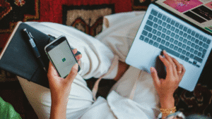 A Person Sitting with a Smartphone and a Laptop